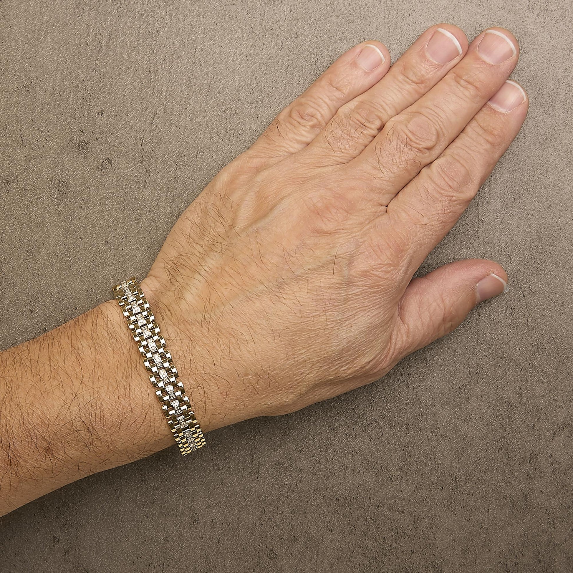 Bracelet with interlinked yellow and white metal sections featuring a row of pave-set white round gemstones, shown worn on a model's wrist from a top-down angle.