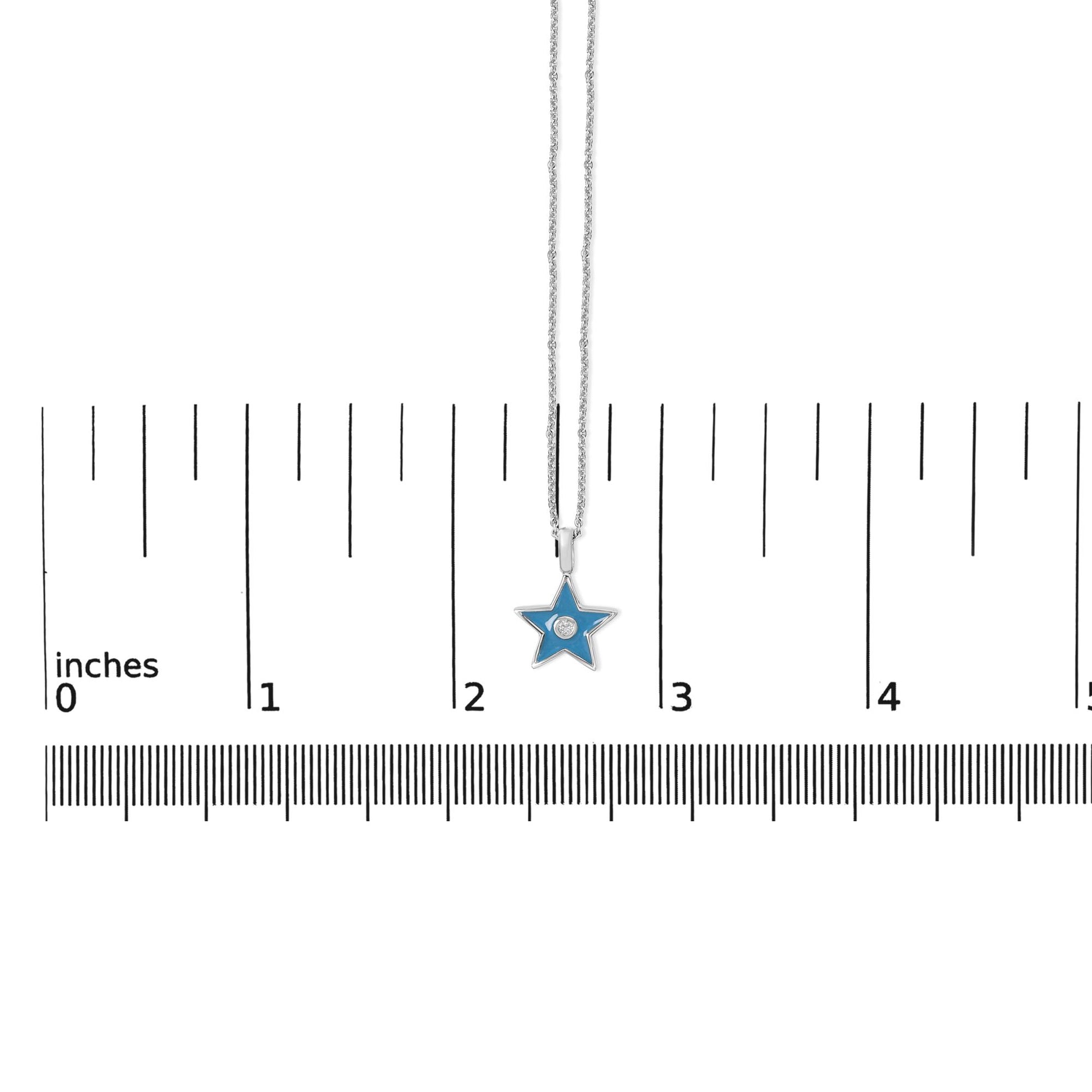 White metal necklace with a star-shaped blue pendant featuring a round white gemstone in bezel setting, shown on a scale from a top-down angle.