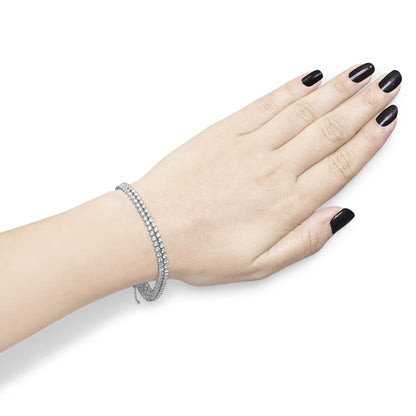 White metal bracelet with two rows of round white gemstones in 4-prong settings, shown on a model's wrist from top angle.