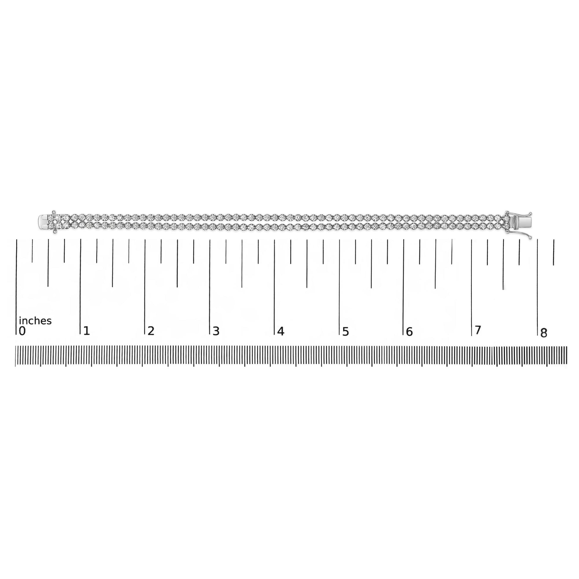 White metal double row bracelet with round white gemstones in 4-prong settings, laid flat on a ruler for size reference, top-down view.