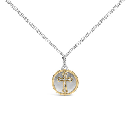Front-facing shot of a necklace with a round two-tone pendant featuring a cross design outlined with white round pave-set gemstones, hanging from a double white chain.