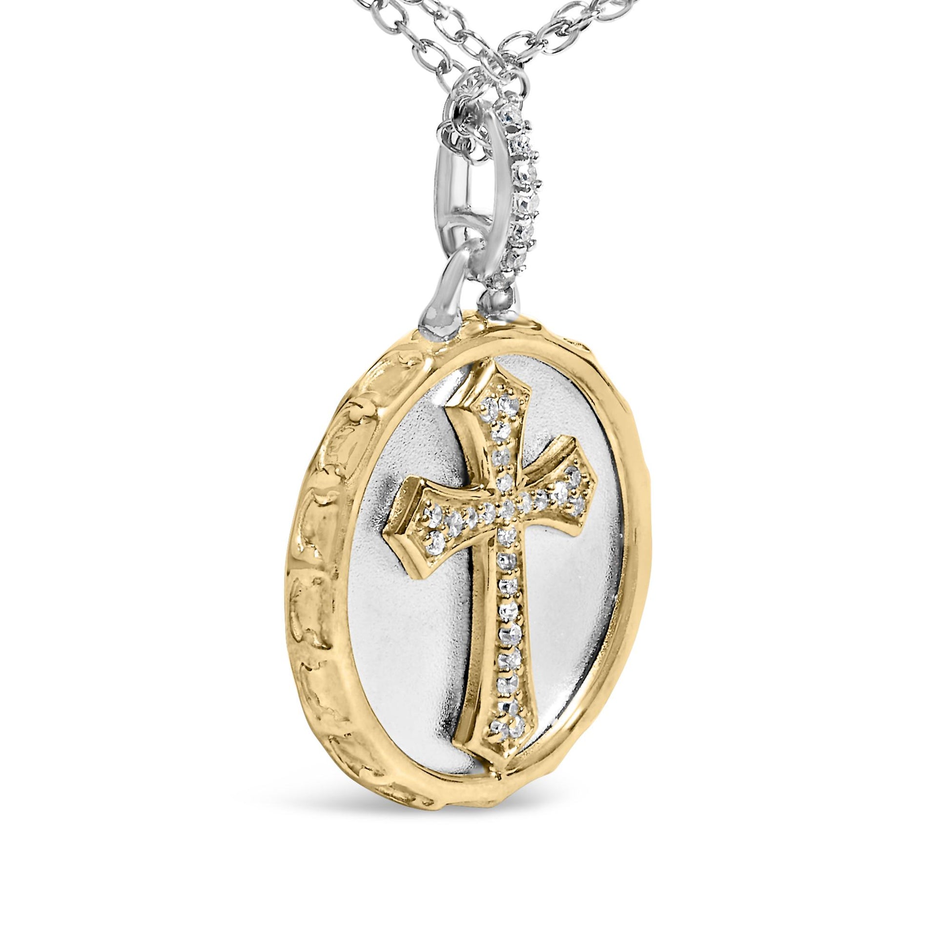 Close-up angled view of a round pendant necklace featuring a raised cross with white pave gemstones, set on a two-tone circular base with a textured yellow outer edge and a smooth white inner surface, hanging from a chain.