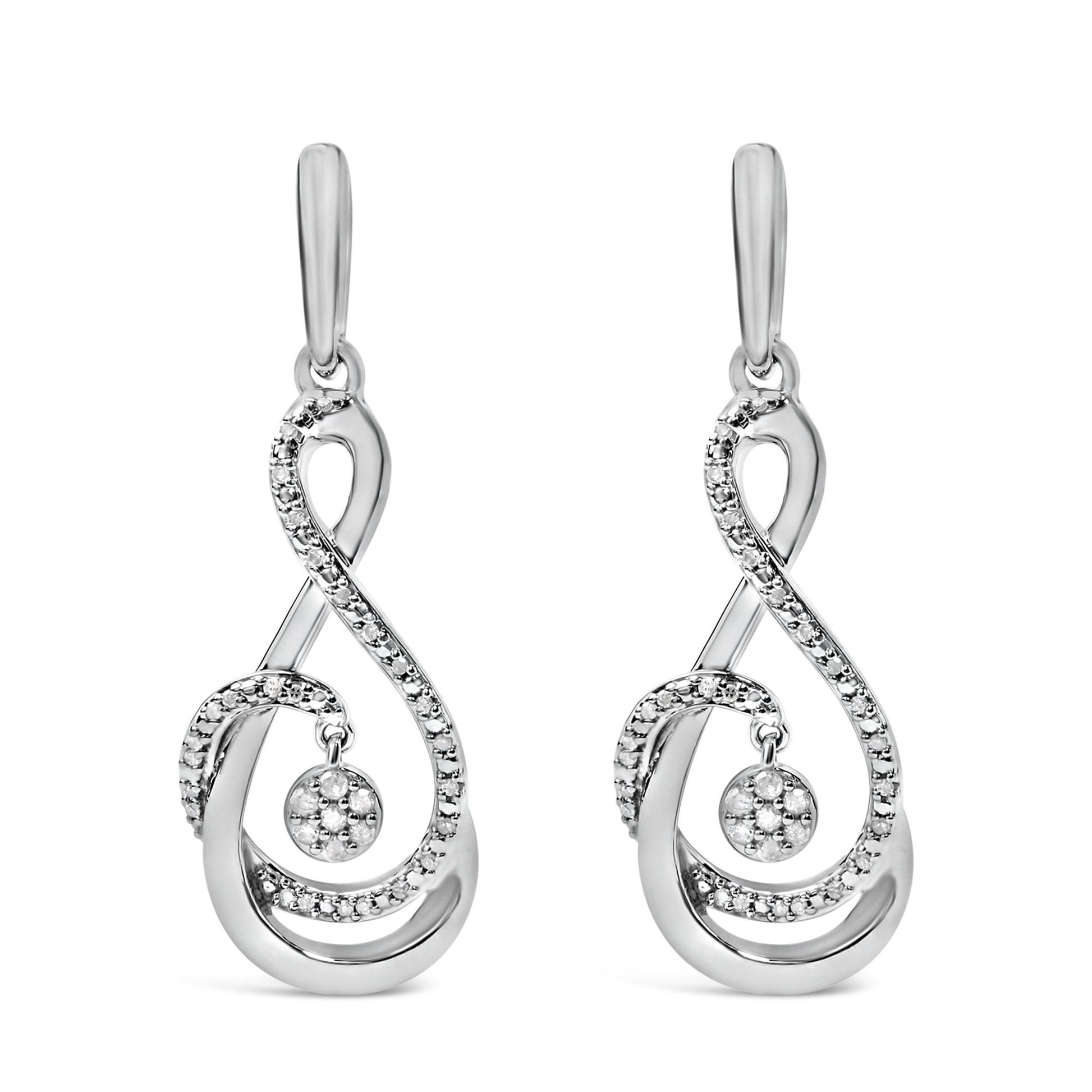 Front view of a pair of white metal earrings with a flowing, looping design accented by multiple round white gemstones in prong settings, including a central circular cluster that dangles.