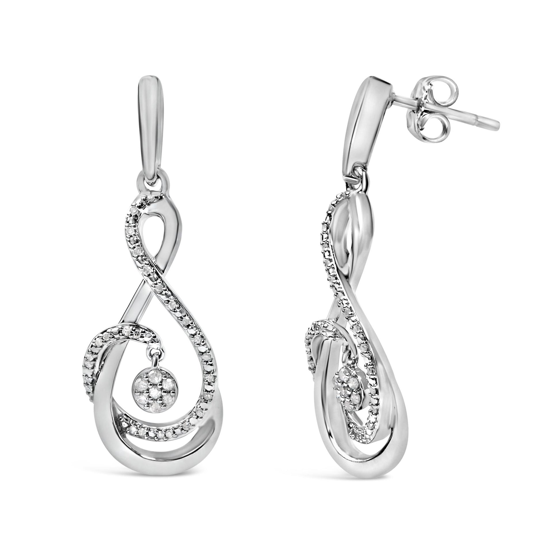 Pair of white metal drop earrings shown from front and side angles, featuring an elegant swirling design accented with small round white gemstones along the curves and a cluster of white gemstones in a circular setting hanging inside the swirl.