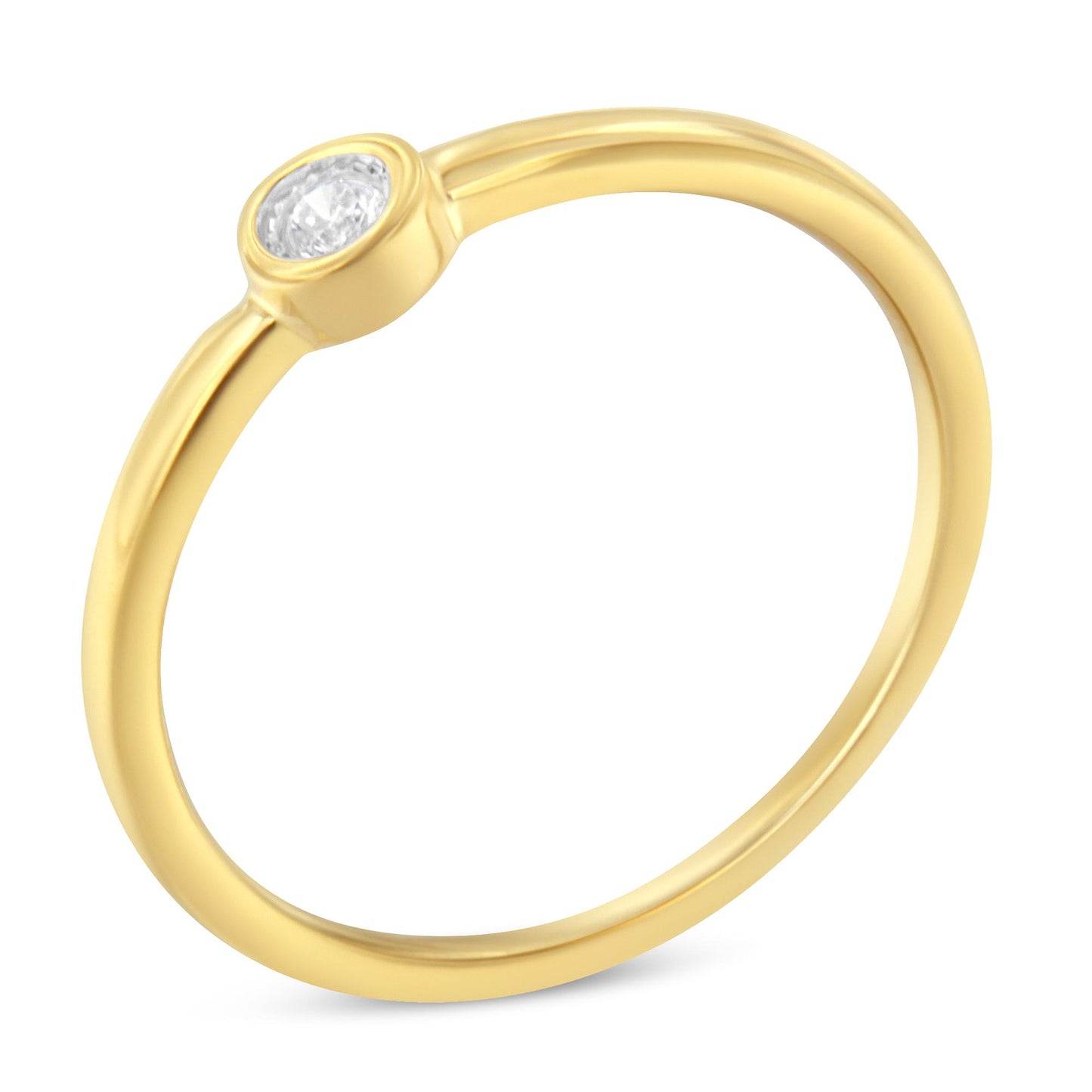 Close-up angle of a yellow metal ring with a single round white gemstone in a bezel setting.