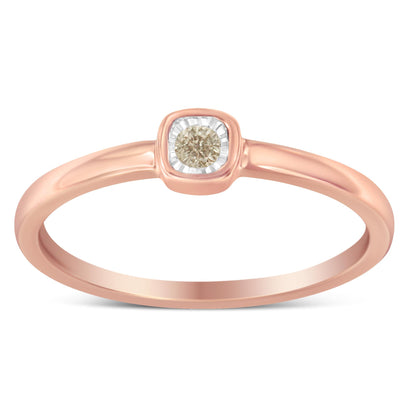 Front-facing view of a rose-colored ring with a single round white gemstone set in a square bezel with a miracle setting.