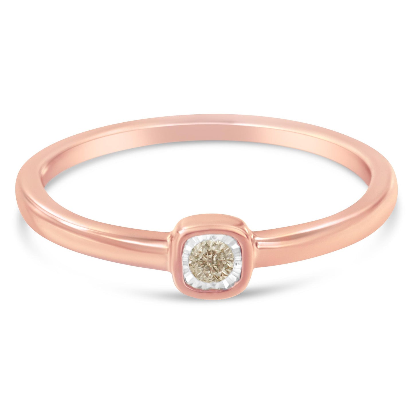 Close-up front angle of a rose-colored ring with a single round white gemstone in a miracle setting.