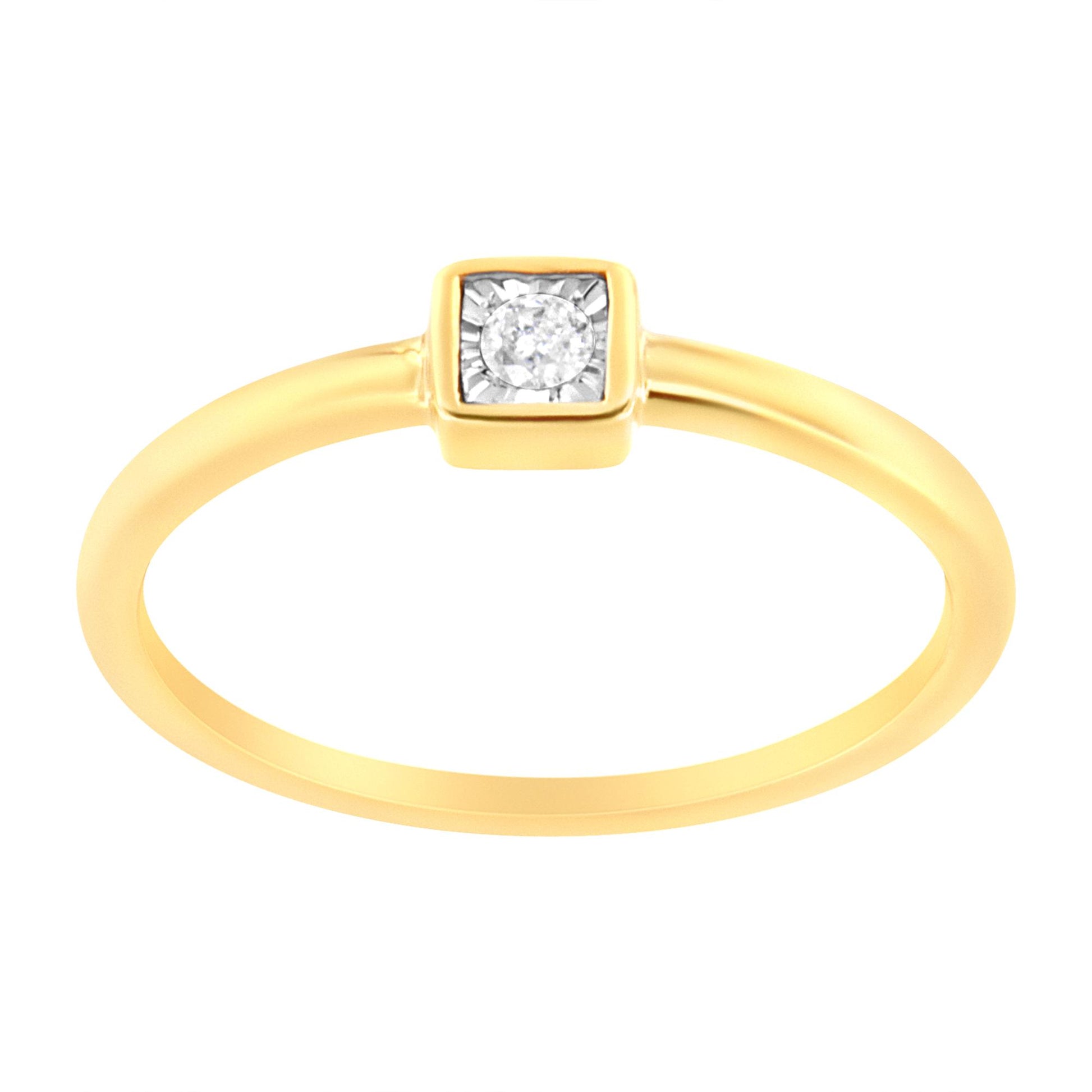 Close-up front angle of a yellow ring with a single round white gemstone in a square setting.