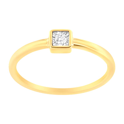 Close-up front angle of a yellow ring with a single round white gemstone in a square setting.