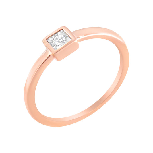 Rose metal ring with a single round white gemstone in a square setting, shown at a slight angle.