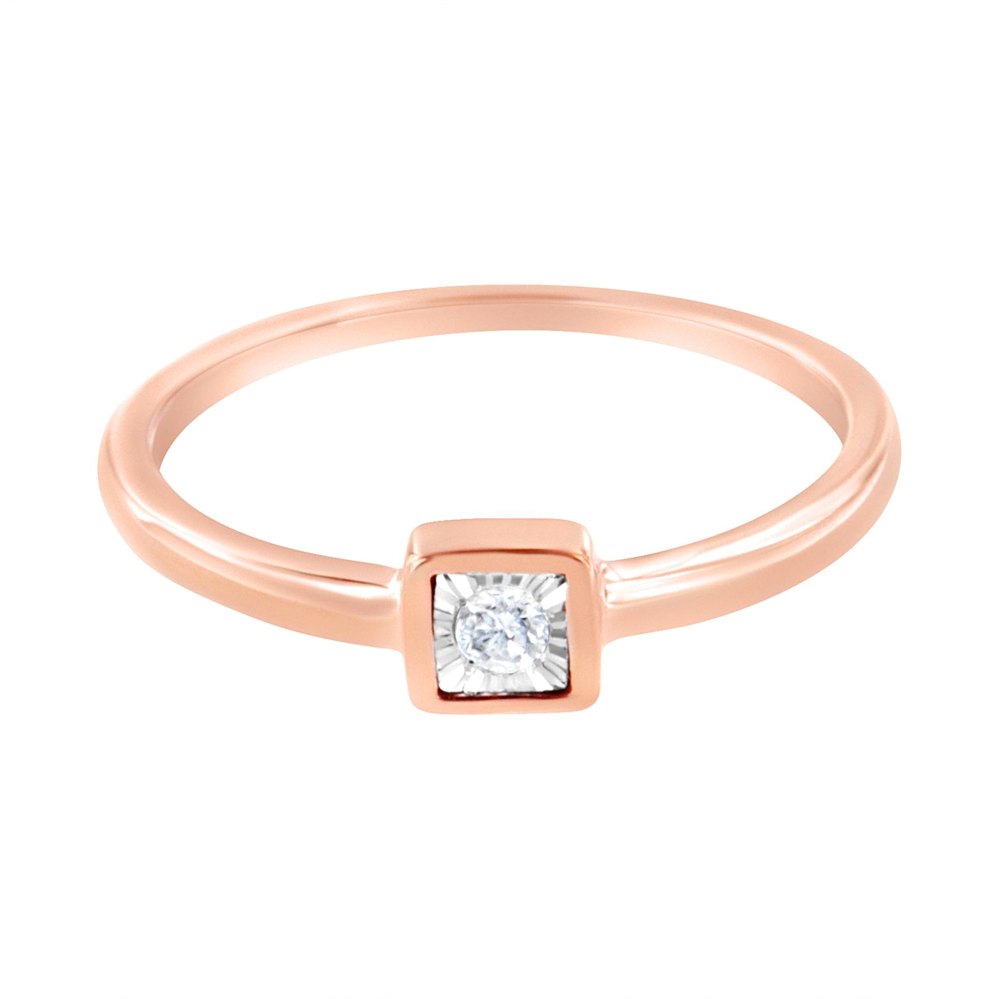 Rose metal ring with a round white gemstone in a square bezel setting, top-down angle.