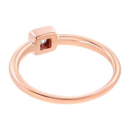 Rose-colored ring with a square-shaped top featuring a round white gemstone in a miracle setting, shown from a side angle.