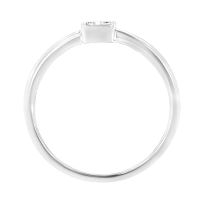 Top-down close-up of a white metal ring with a single round white gemstone in a miracle setting.