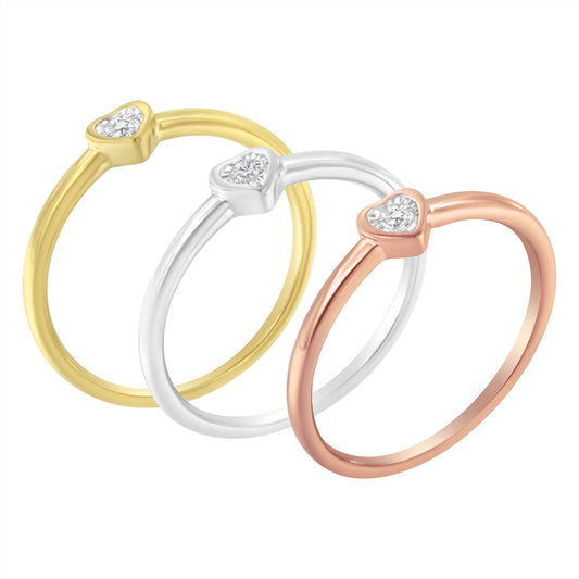 Three rings in yellow, white, and rose metal colors with heart-shaped settings each featuring a round white gemstone, shown from a front angle.