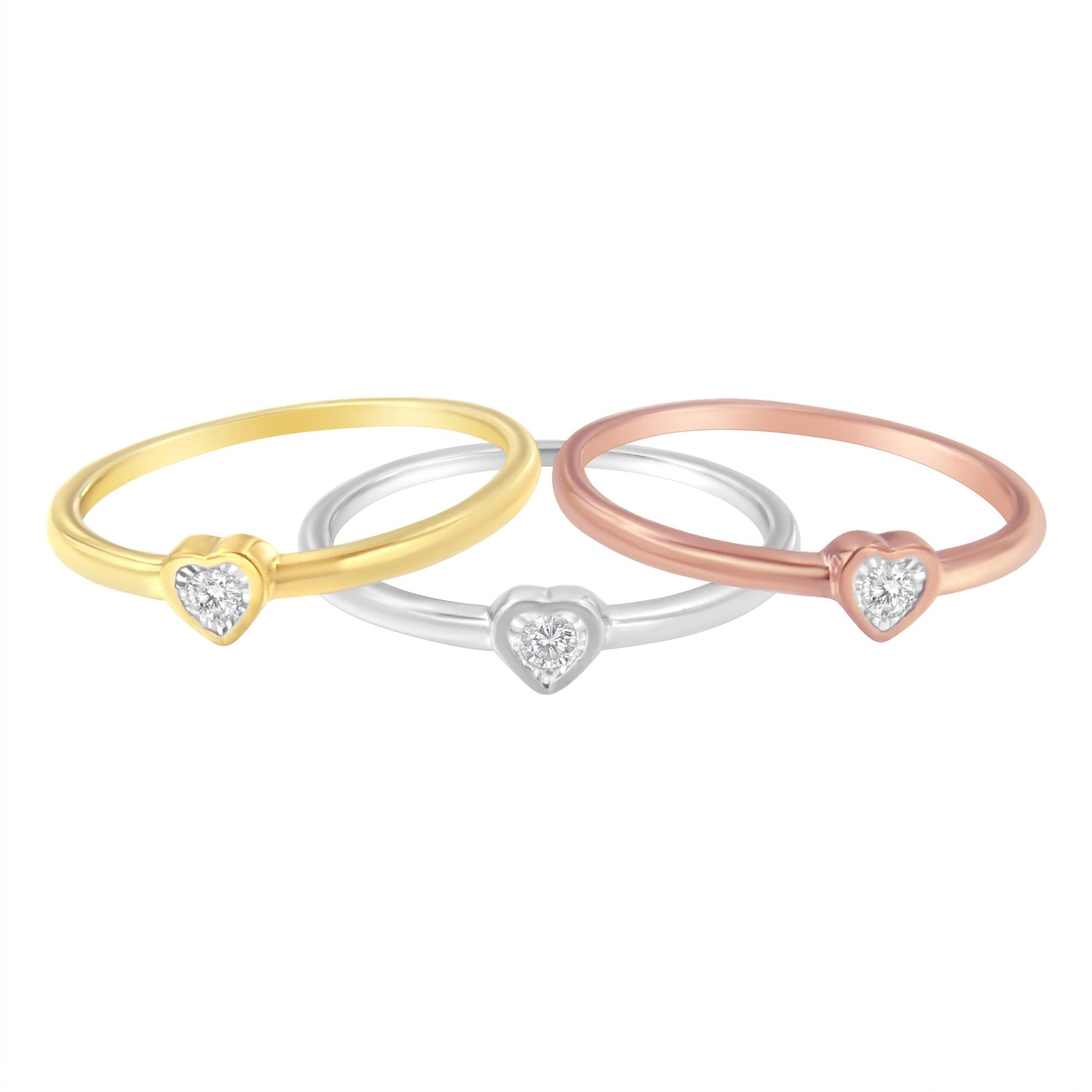Three thin rings in yellow, white, and rose metal colors with heart-shaped settings each holding a round white gemstone, shown in a front angled view.
