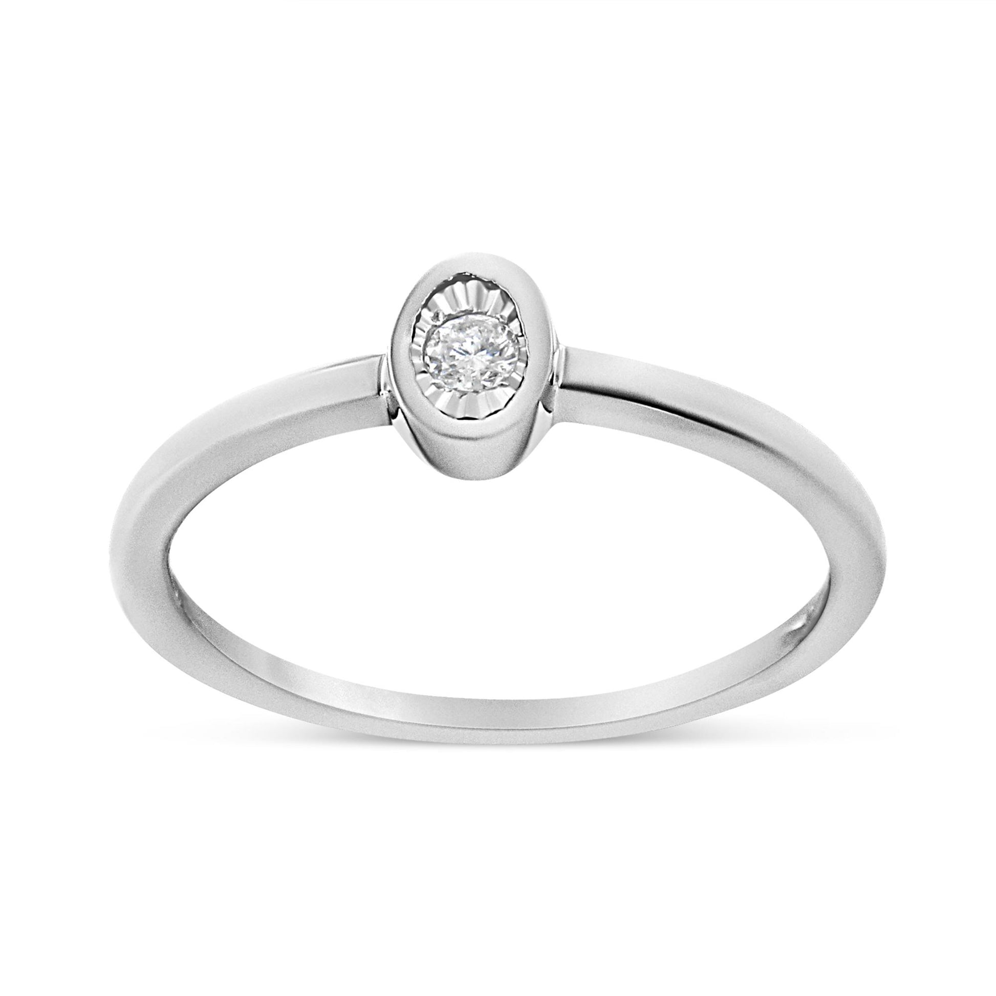 Close-up front angle of a white metal ring featuring a single round white gemstone in a bezel setting.
