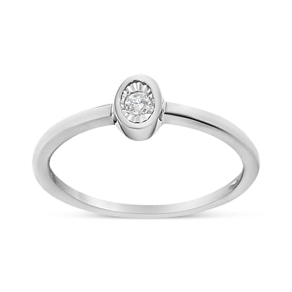 Close-up front angle of a white metal ring featuring a single round white gemstone in a bezel setting.