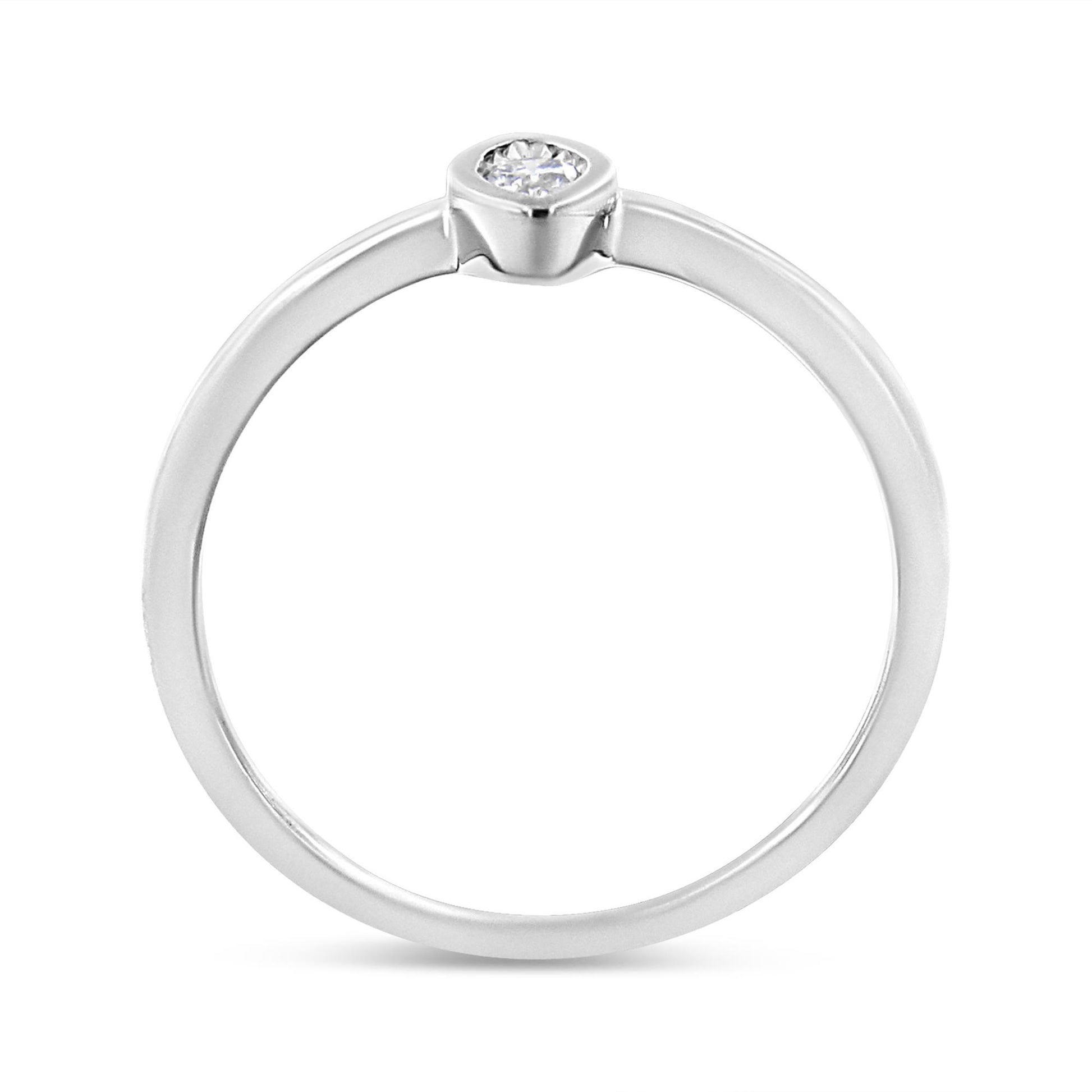 White metal ring with a round white gemstone in a bezel setting, shown from a front angle.