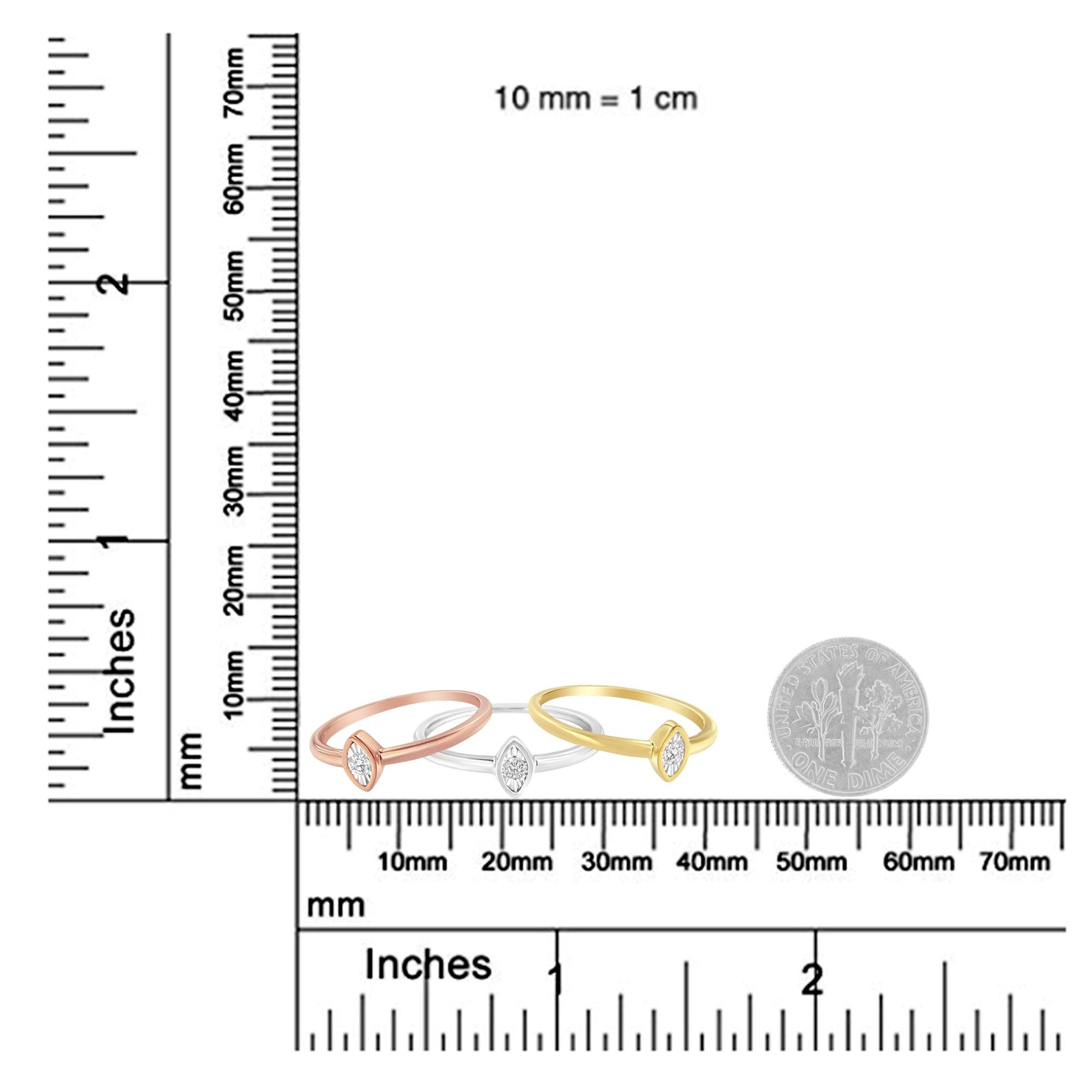 Front-facing view of three rings in yellow, white, and rose metal colors placed side-by-side on a ruler for size reference, each ring featuring a round white gemstone in a miracle setting.