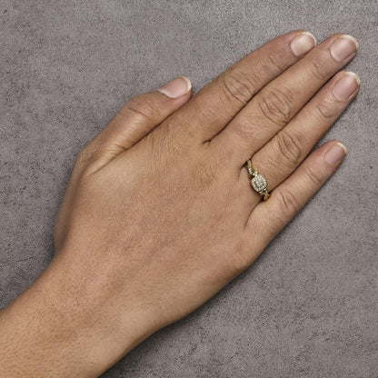 Yellow metal ring with a square cluster of small white gemstones in prong settings, shown worn on a model's hand from a top angle.