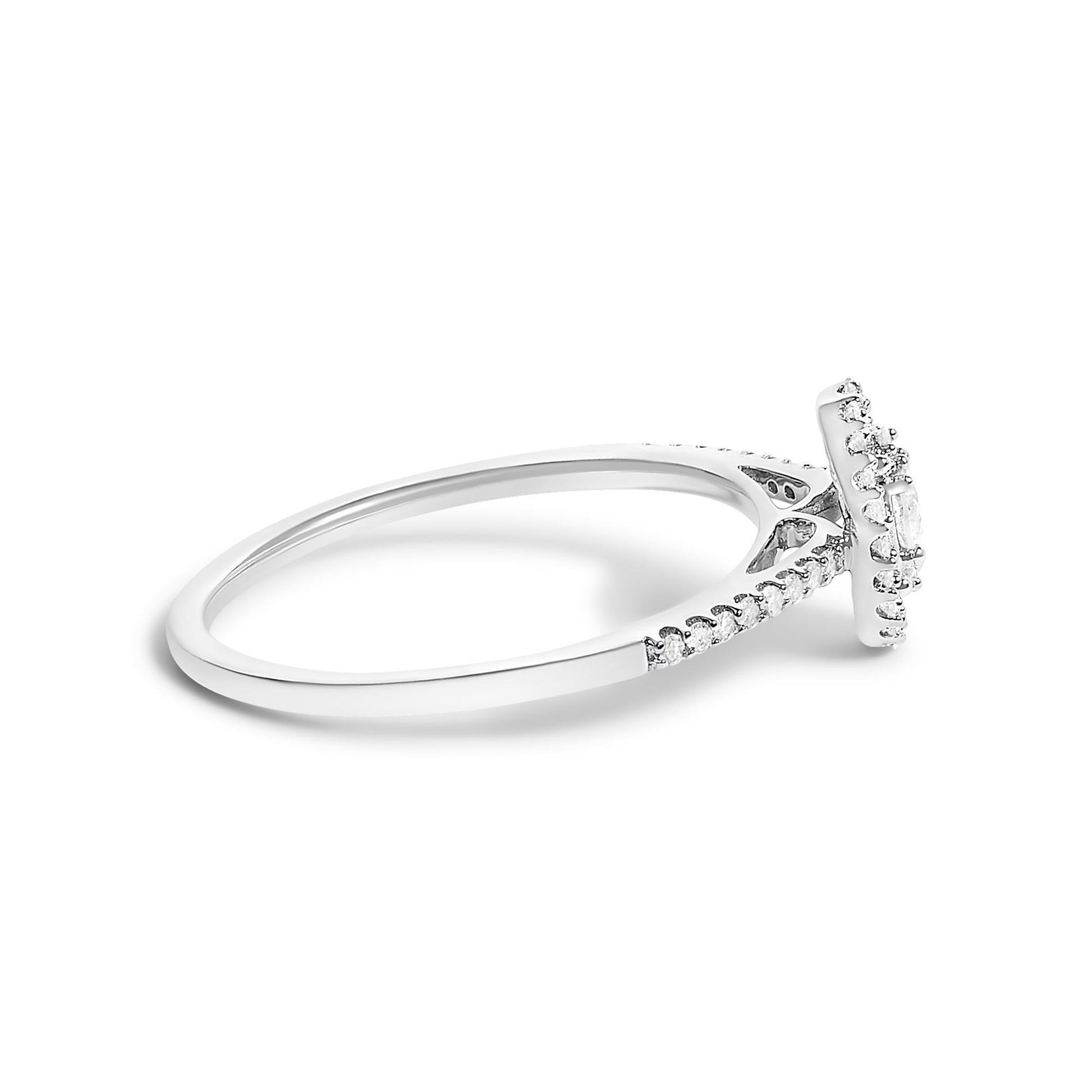Side angle view of a white metal ring featuring a raised setting with multiple small white round gemstones along the band and a cluster of white round gemstones on top.