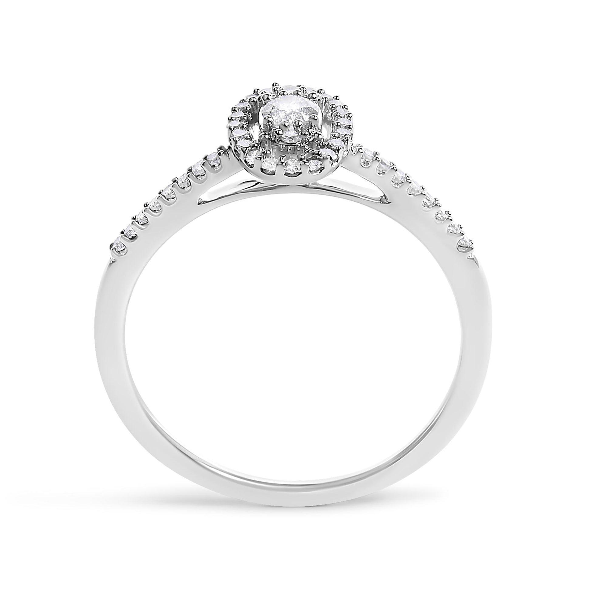 White metal ring shown from the front angle, featuring a round center gemstone in prong setting, surrounded by a halo of smaller white gemstones, and additional white gemstones set along the upper half of the band.