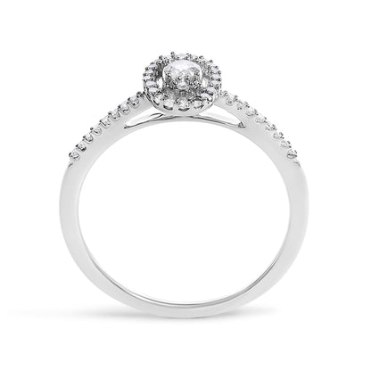 White metal ring shown from the front angle, featuring a round center gemstone in prong setting, surrounded by a halo of smaller white gemstones, and additional white gemstones set along the upper half of the band.