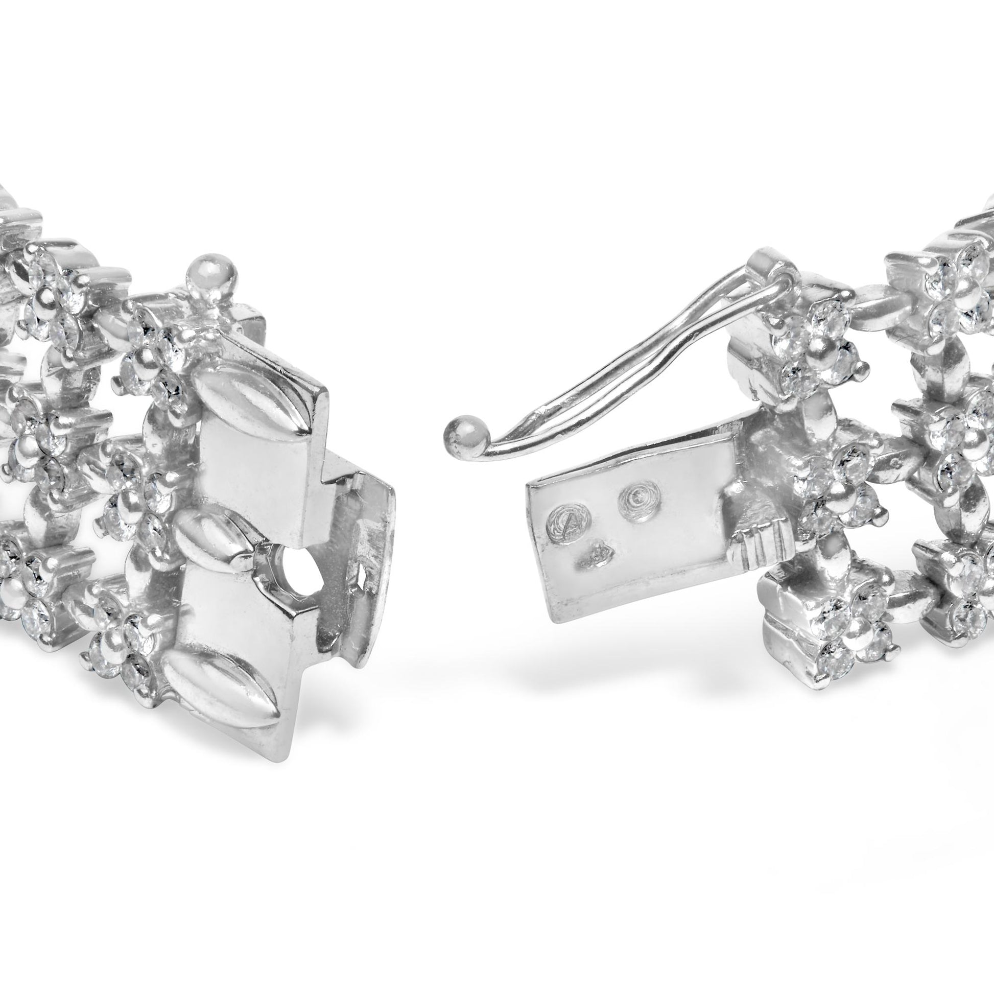 Close-up front angle of a white metal bracelet with round white gemstones in 4-prong settings, showing the clasp open.