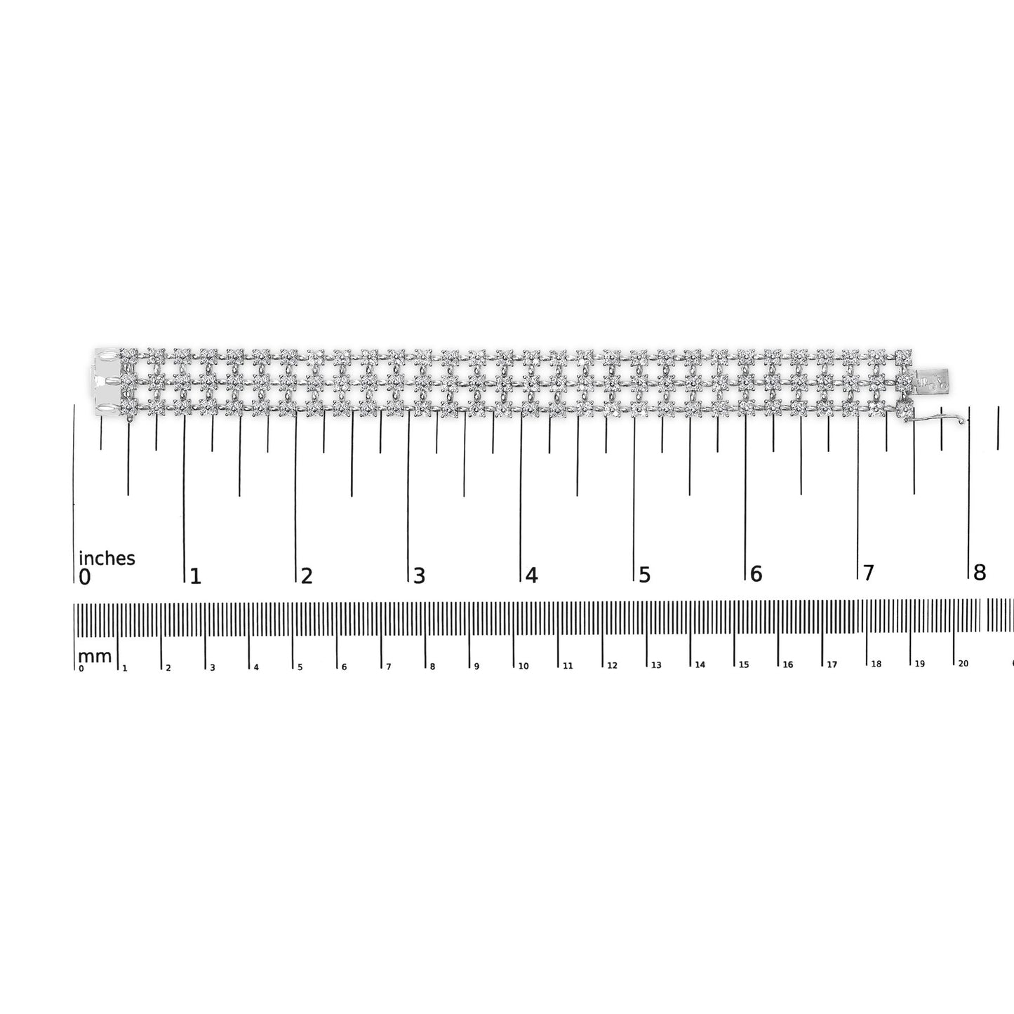 White metal bracelet with multiple rows of round white gemstones in 4-prong settings, laid flat on a ruler for size reference, top-down angle.