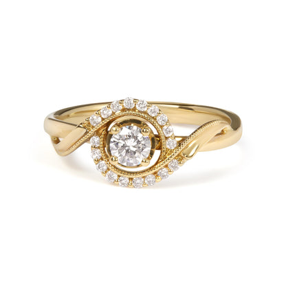Yellow metal ring with a round white gemstone in a four-prong setting at center, surrounded by a swirl of smaller round white gemstones in shared prong settings, front angle view.