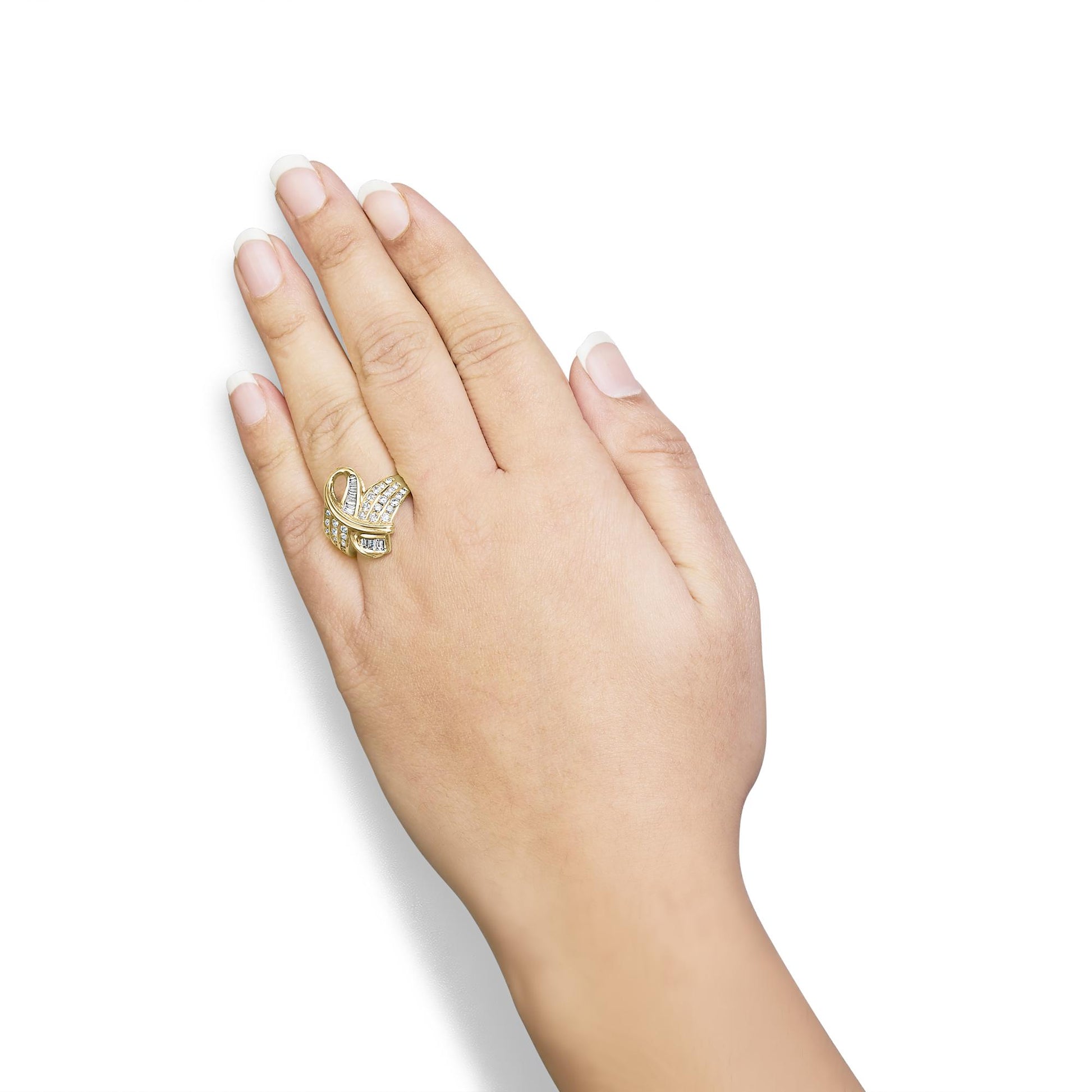 Yellow metal ring with intertwined bands featuring white round and baguette channel-set gemstones, worn on a hand, top-down angle.