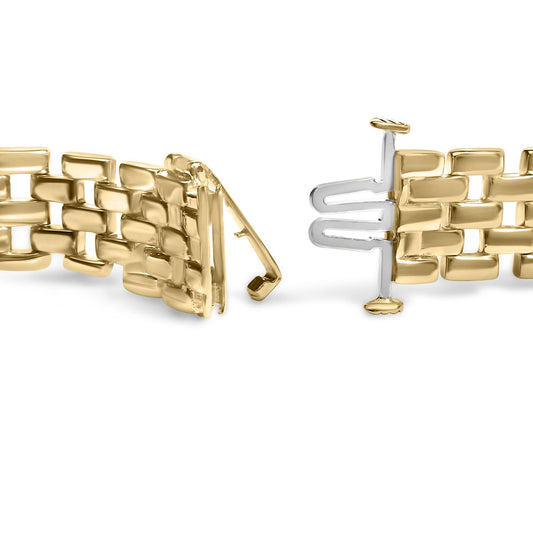 Close-up side angle of an open yellow metal bracelet with a detailed clasp shown on a white background.