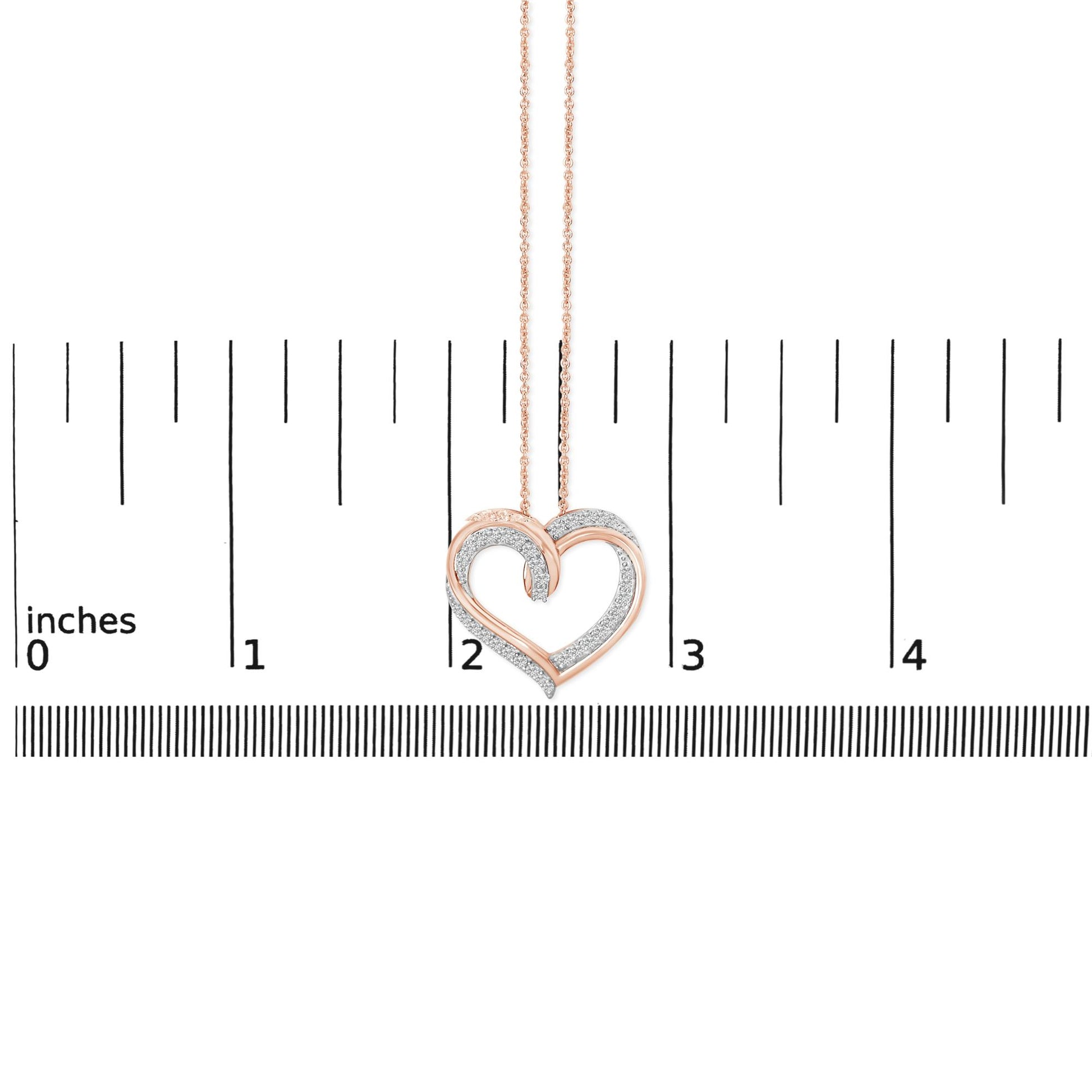 Heart-shaped necklace with alternating white and rose metal curves, adorned with white round gemstones in prong settings, shown on a ruler scale from front angle.