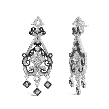 Pair of white and black metal drop earrings with intricate scrollwork design, decorated with white princess and round shaped gemstones, shown from front and side angle on a white background.