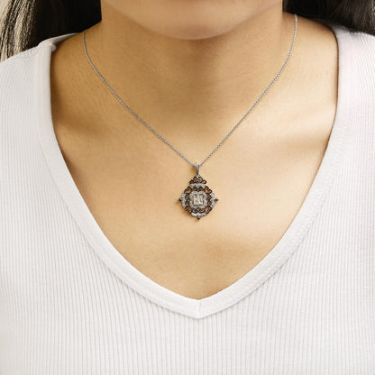 Necklace shown worn on a model, featuring a white and black metal pendant with an ornate design surrounding four white princess-shaped gemstones in the center and black round gemstones decoratively placed, shot from the front.