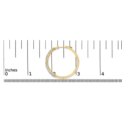 Close-up front view of a single yellow and white hoop earring with white baguette-shaped gemstones set along half of the outer edge, shown on a ruler scale.