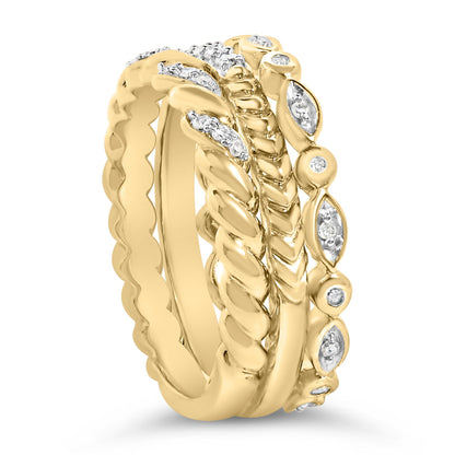 Close-up front angle of a stacked set of four yellow and white metal rings with round white gemstones in pave settings, featuring twisted, chevron, scalloped, and marquise shapes.