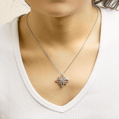 Close-up front view of a model wearing a white metal necklace with a flower-shaped pendant adorned with round white gemstones in prong settings.