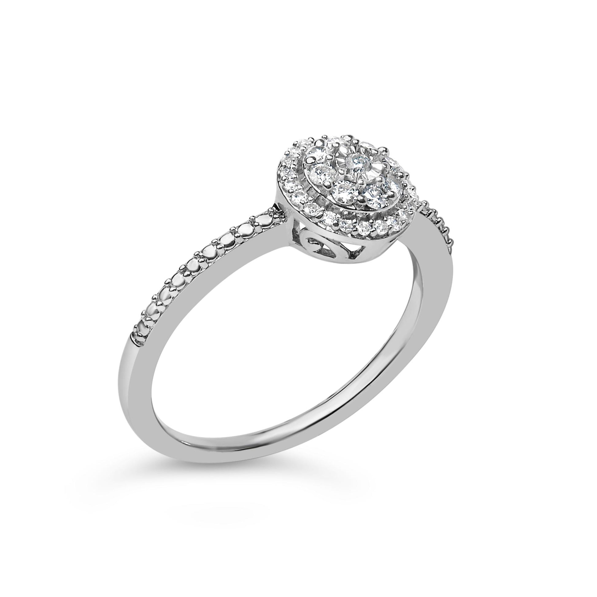 White metal ring with round white gemstones in prong settings forming a circular cluster on top and additional stones along the upper band, shown in a three-quarter angle.