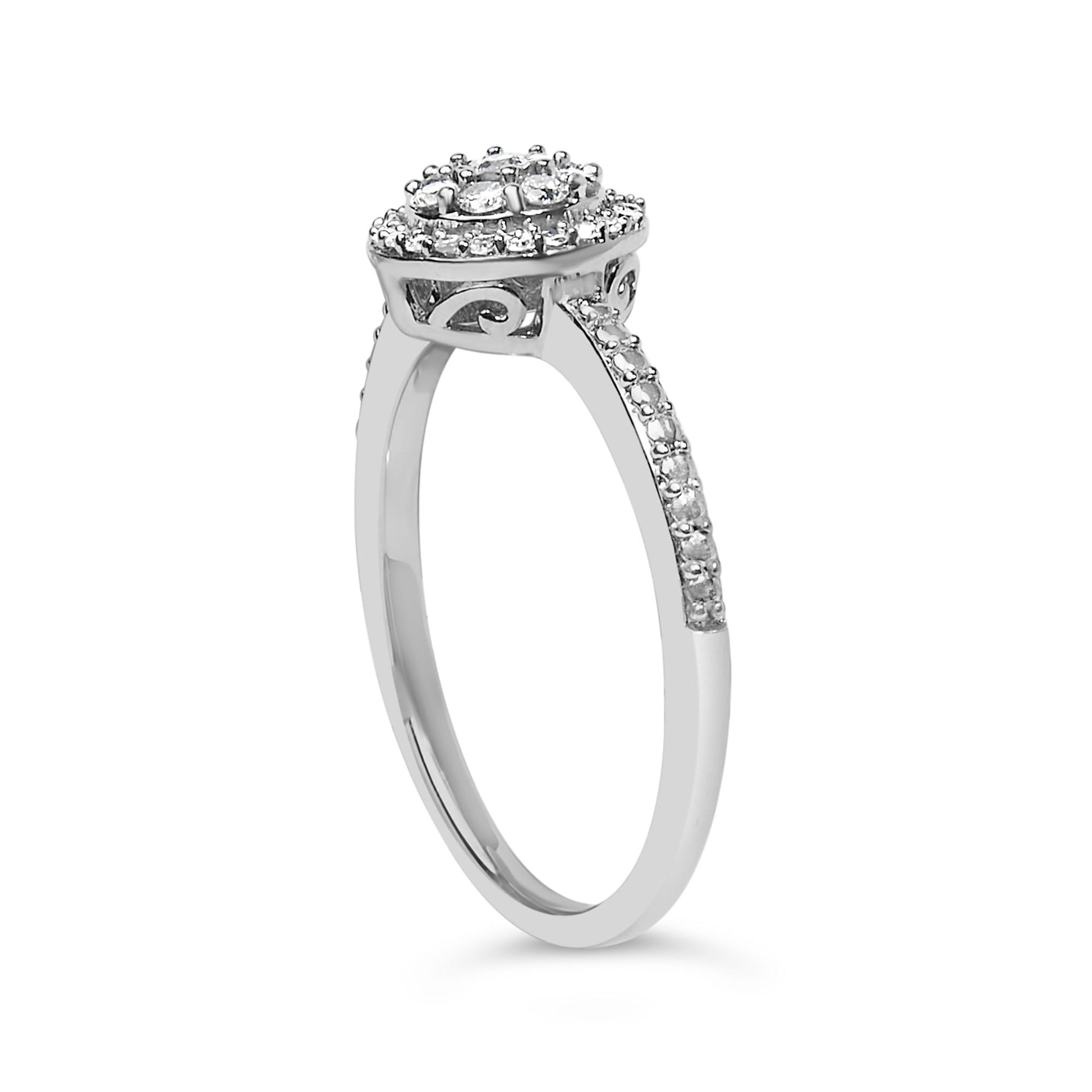 White metal ring with a cluster of round white gemstones in prong settings on the head and shoulders, shown from a side angle on a white background.
