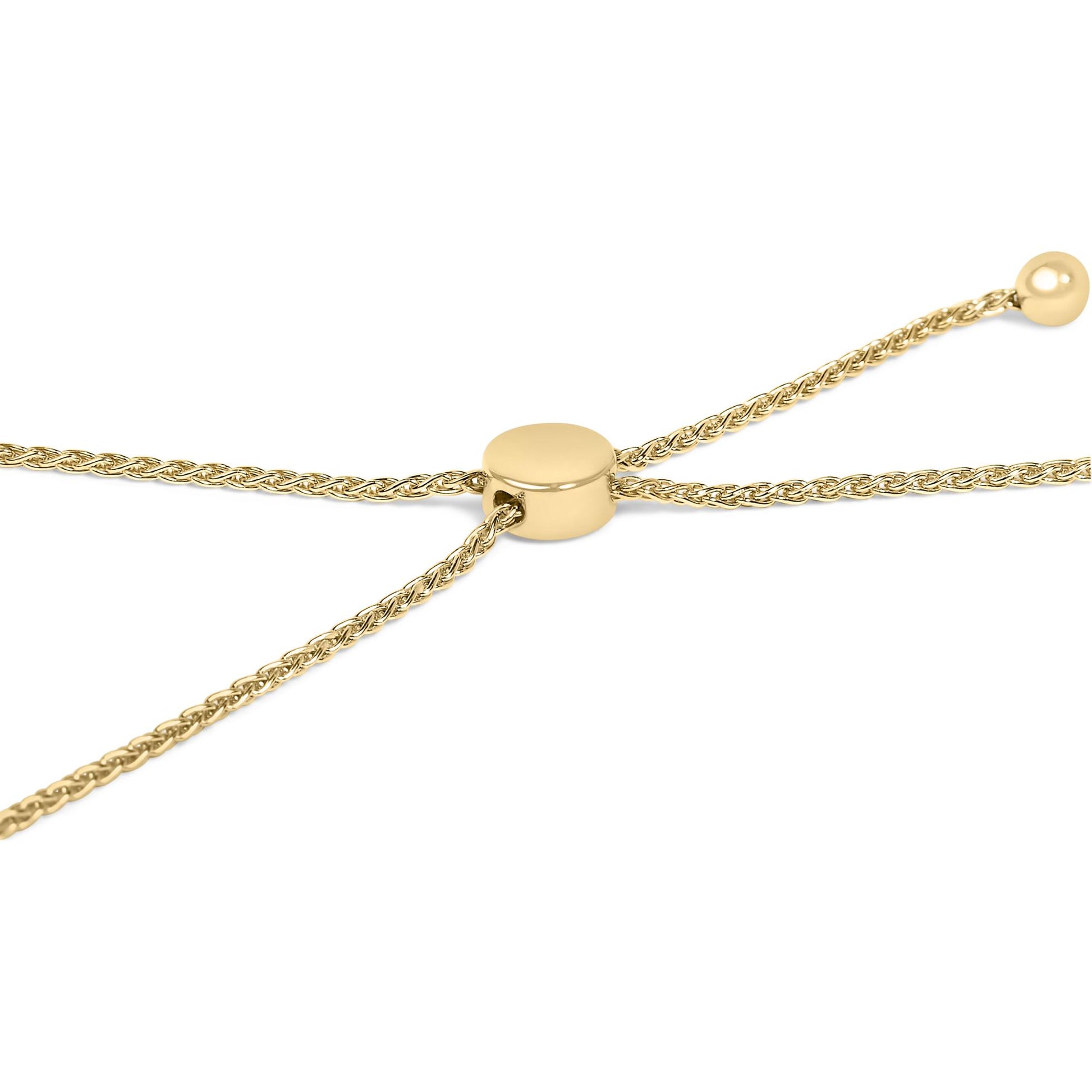 Close-up angled view of a yellow metal bracelet with woven chain detail and a smooth round slider clasp.