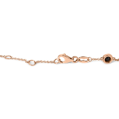Close-up side angle of a rose metal chain bracelet featuring a clasp and a round black gemstone in a bezel setting.