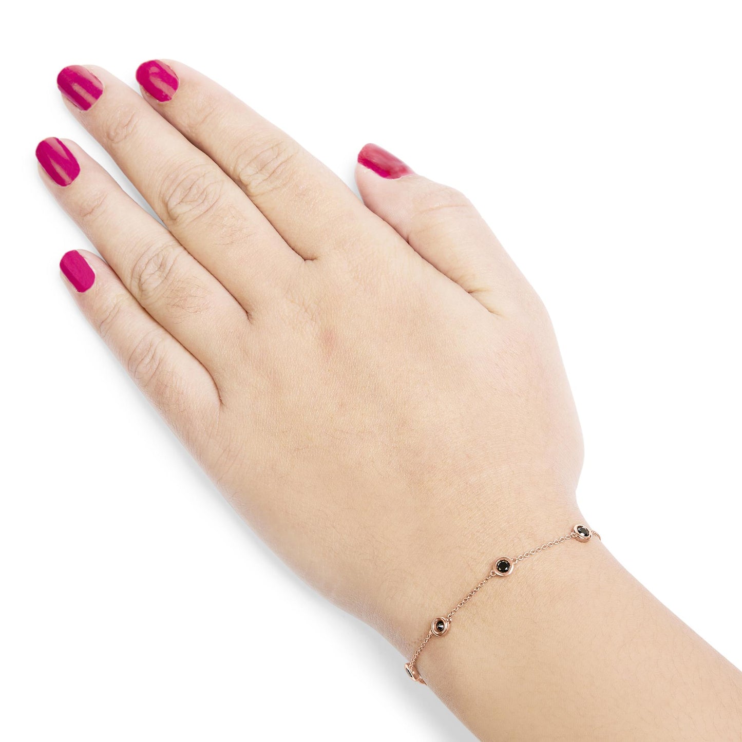 Rose metal bracelet with round black gemstones in bezel settings, shown on a model's wrist from a top angle.