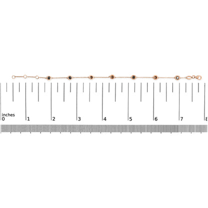 Rose metal bracelet with round black gemstones in bezel settings, laid flat on a ruler for size reference, shot from above.