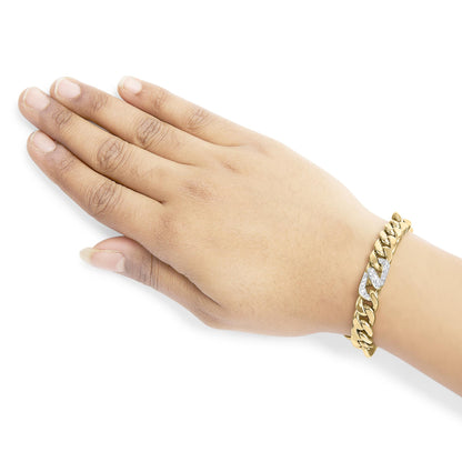 Close-up side angle of a yellow metal bracelet on a model's wrist with a linked design, featuring two links adorned with multiple white gemstones in shared prong settings.