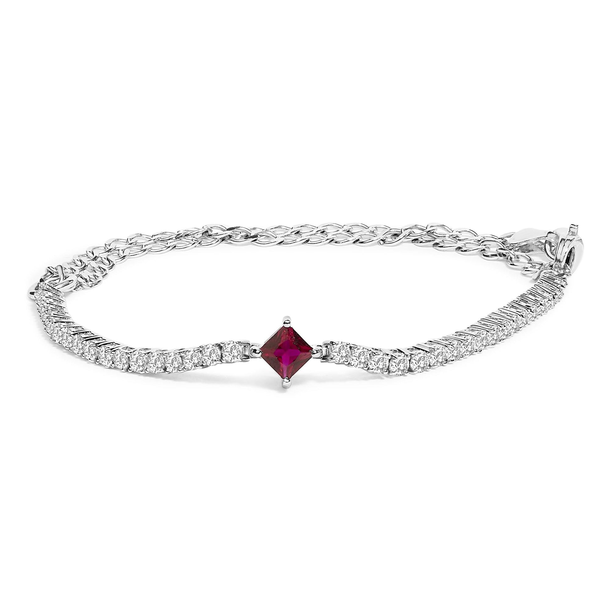 White metal bracelet with round white gemstones and one red princess-shaped gemstone in the center, shown in a close-up angled front view.