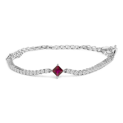 White metal bracelet with round white gemstones and one red princess-shaped gemstone in the center, shown in a close-up angled front view.