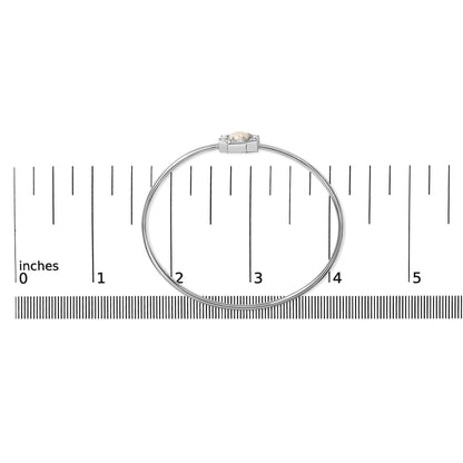 White metal bracelet with a central round white opal gemstone surrounded by round and baguette white gemstones, shown flat on a ruler for scale, top-down view.