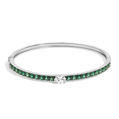 Bracelet with a white metal band, featuring a row of round green gemstones along the front and a single oval white gemstone center-set, shown from a front angle.