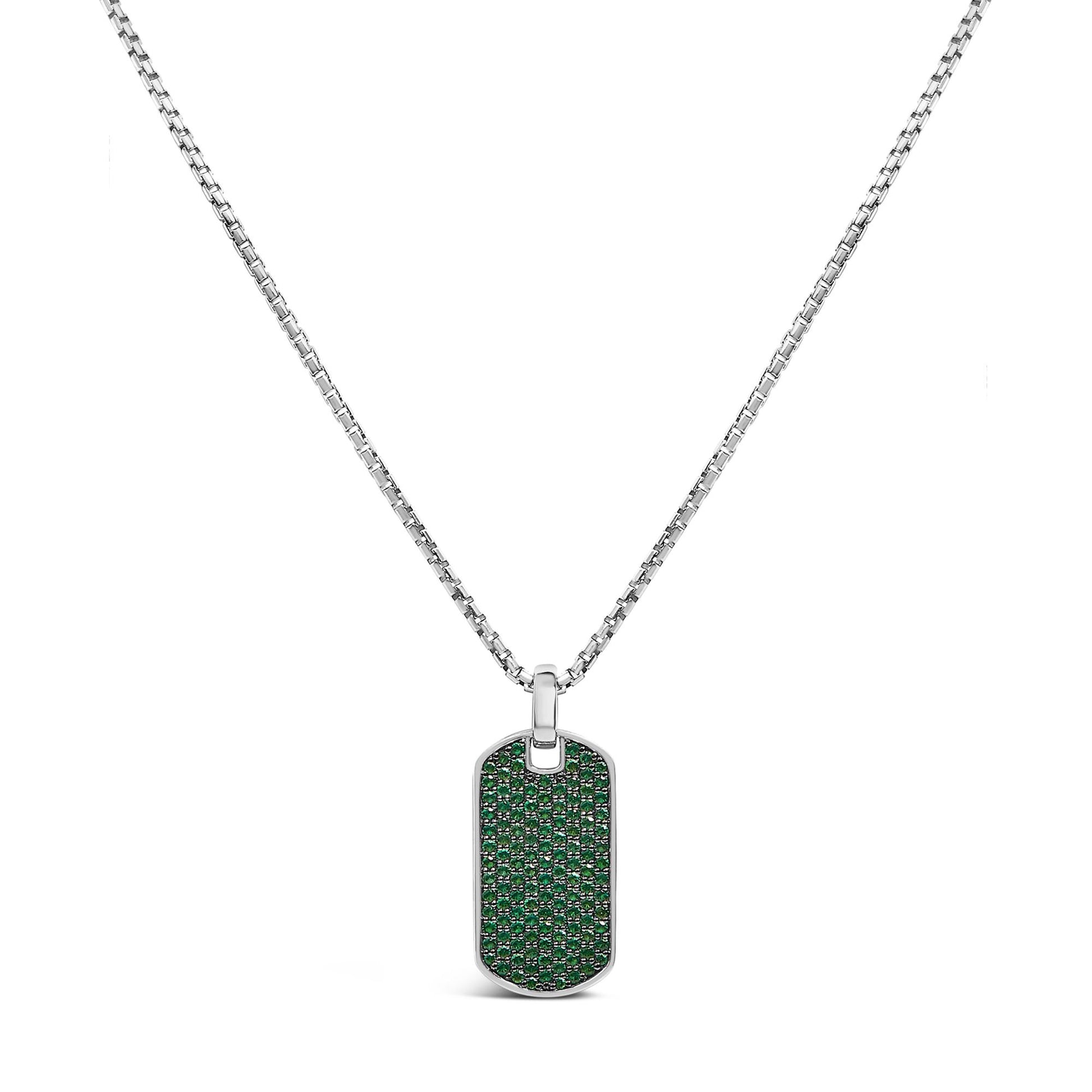 Front-facing shot of a white metal rectangular pendant necklace with rounded edges, fully paved with small round green gemstones in a shared prong setting, hanging on a white metal chain.